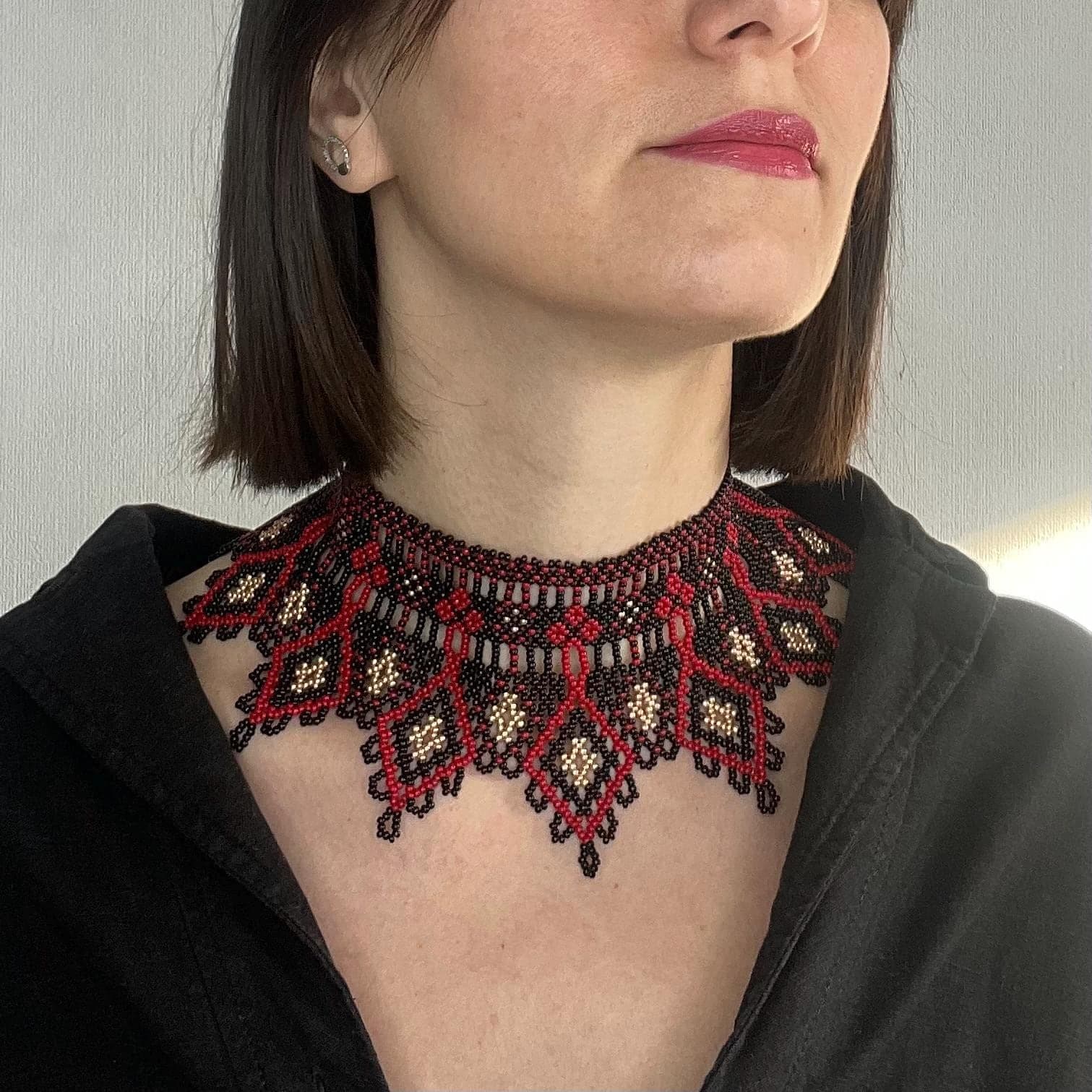 Beaded collar in black, deep red and gold with geometric and floral motifs