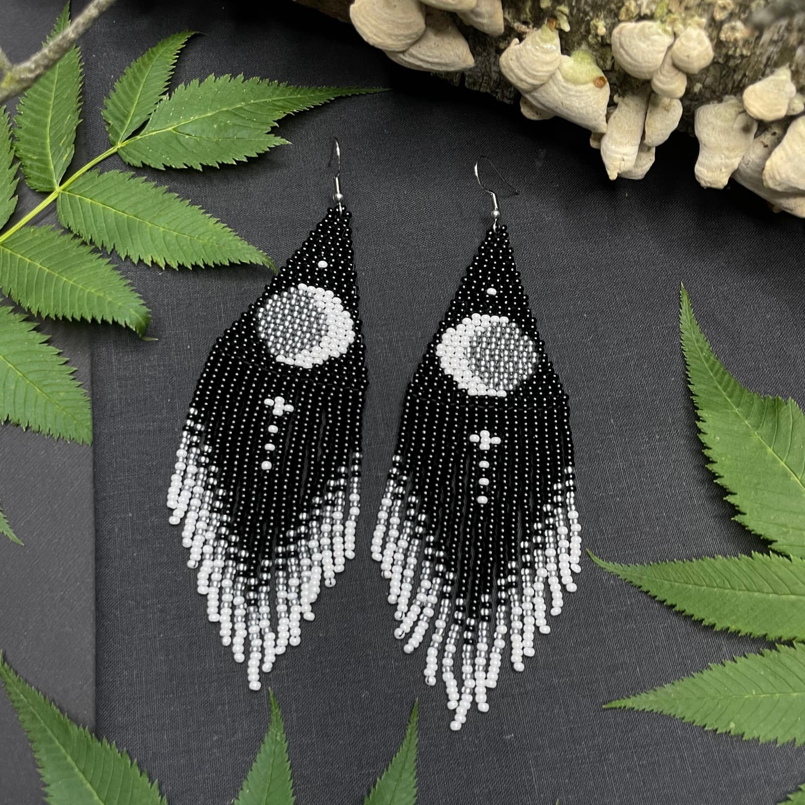 Black and white beaded earrings with a crescent moon motif