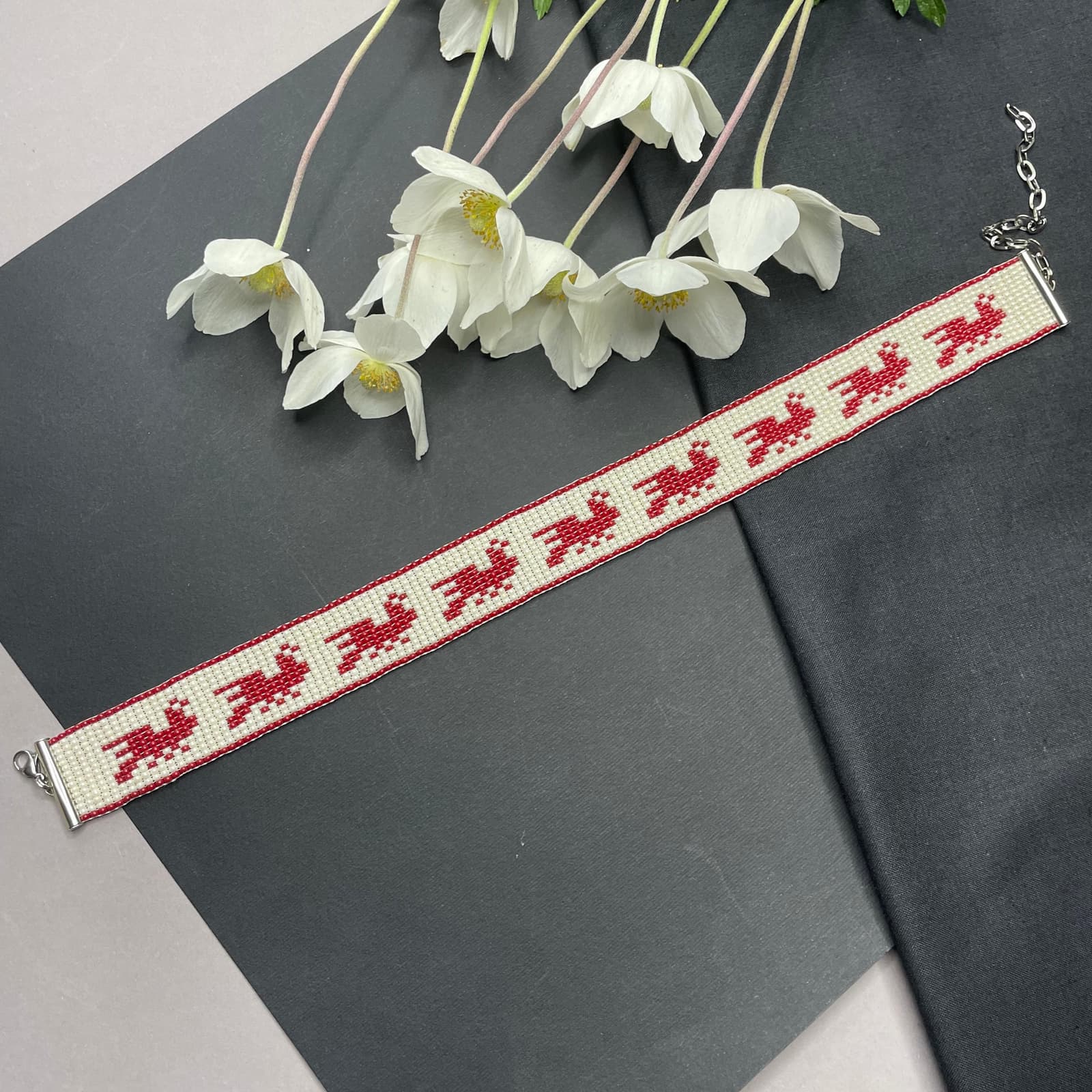 Narrow beaded choker with red bird motifs on an ivory ground