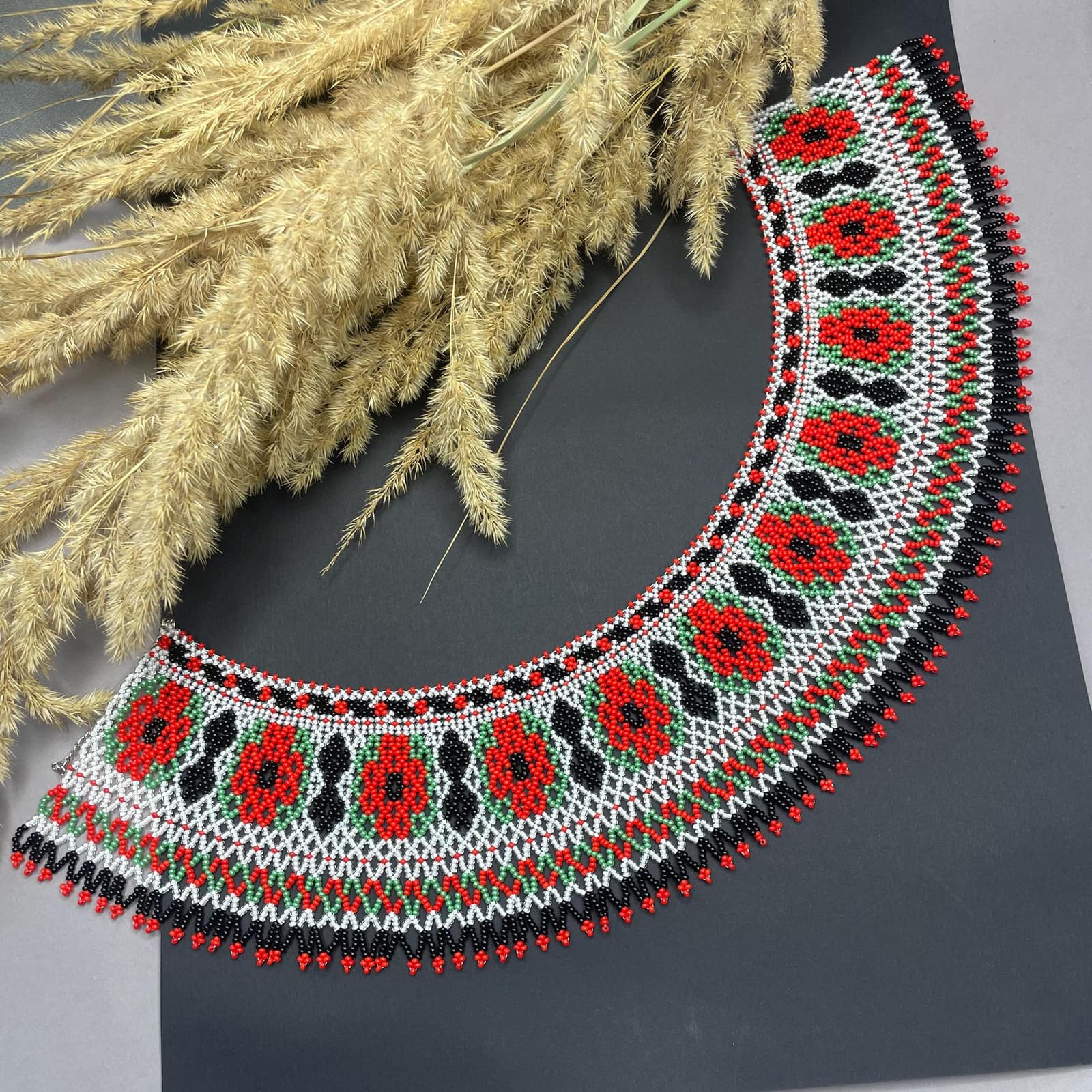 Beaded collar necklace with red poppies on a white and black ground
