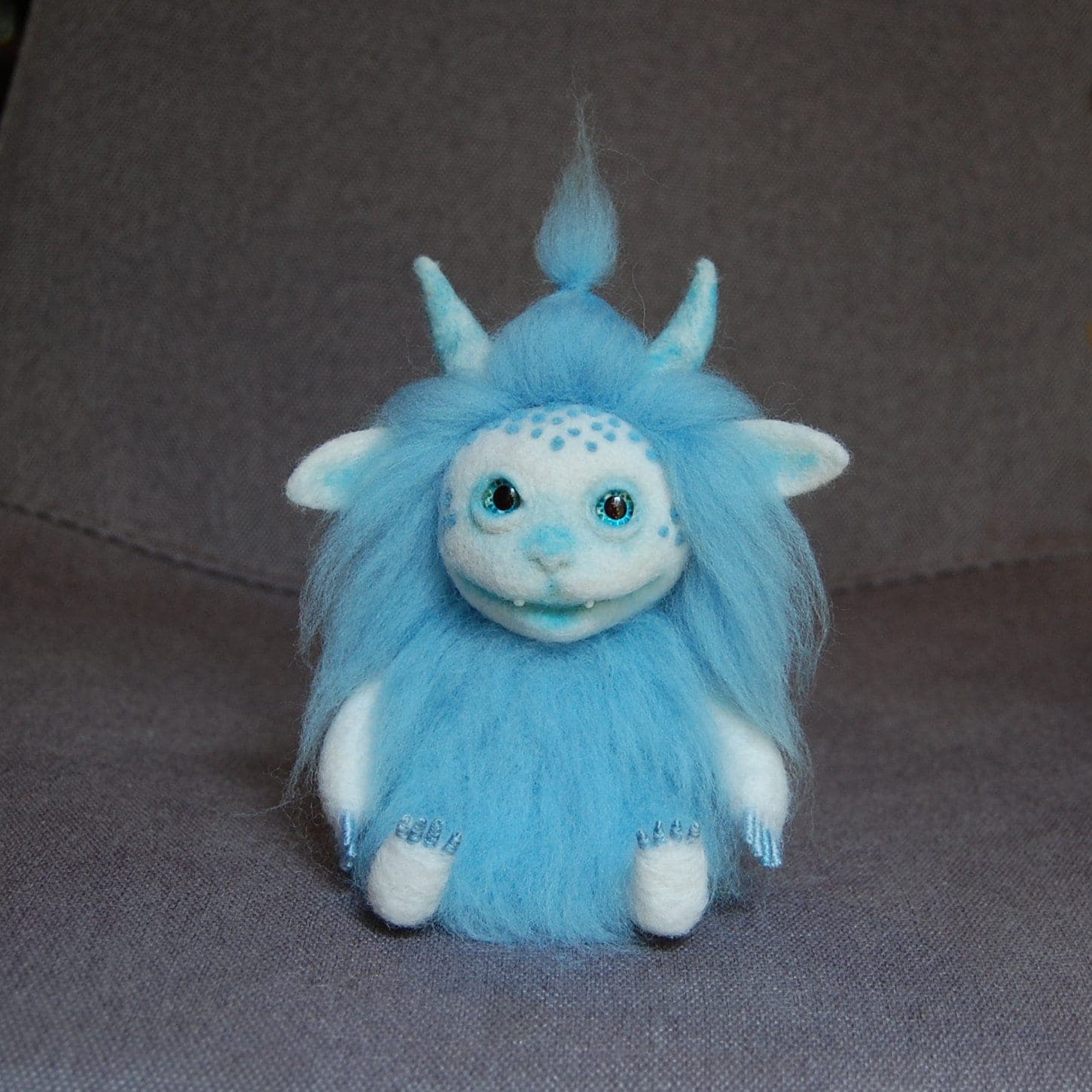 Needle-felted pink fantasy creature with small horns and glass eyes